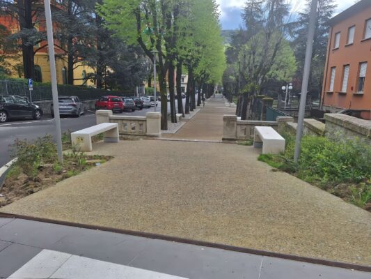 Vista della passeggiata in calcestruzzo architettonico con inerti locali nel giardino pubblico di Vergato